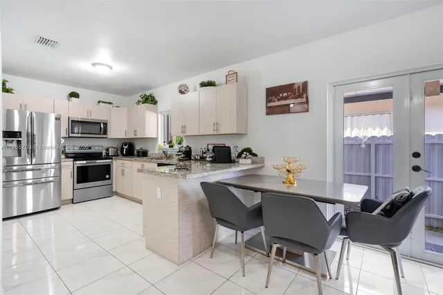 a kitchen with stainless steel appliances kitchen island granite countertop a sink and cabinets