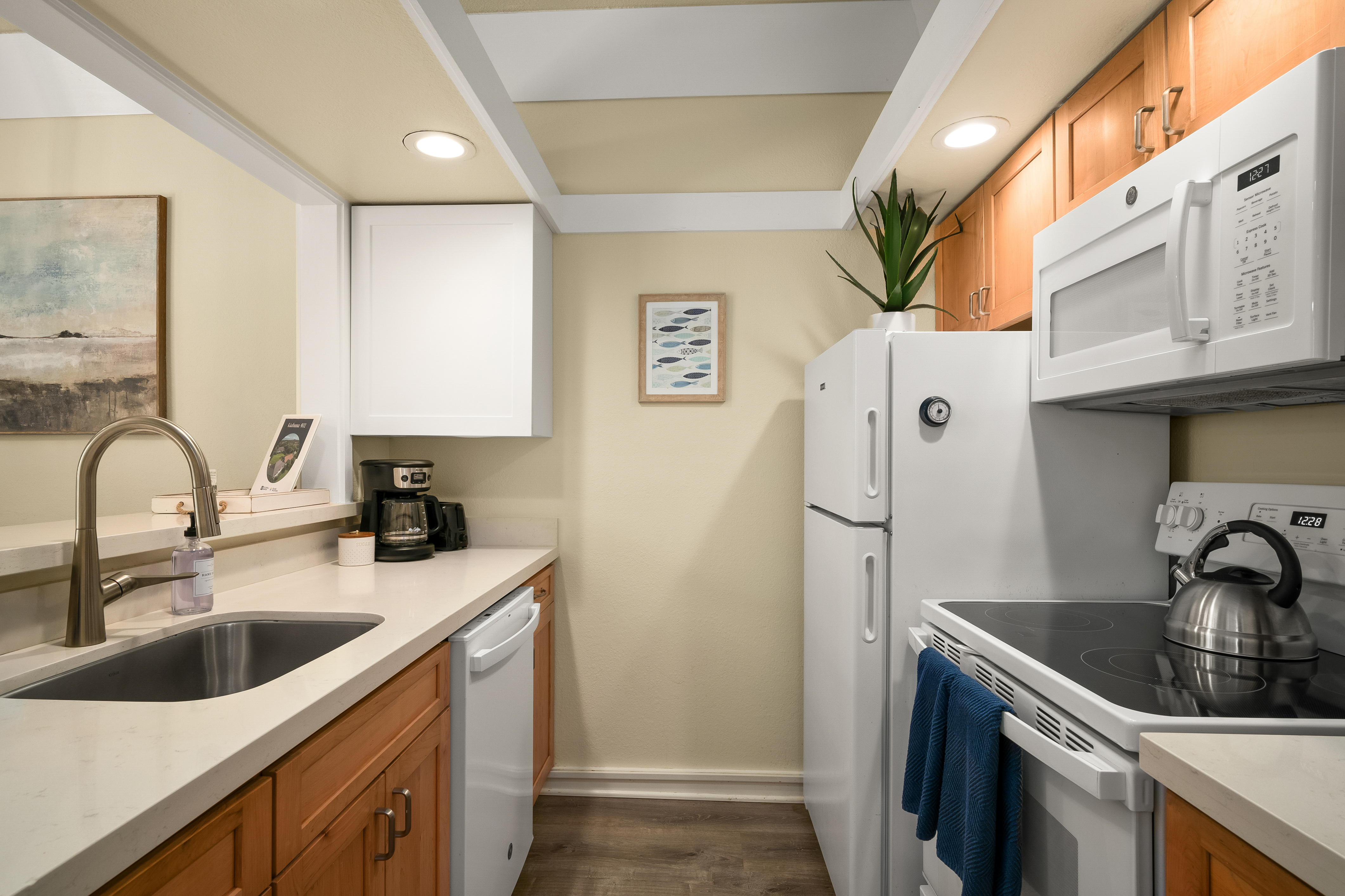 2253 Poipu Road, Unit 402 Koloa, HI 96756 - Photo 7 of 16 a kitchen with stainless steel appliances granite countertop a sink a refrigerator and wooden cabinets