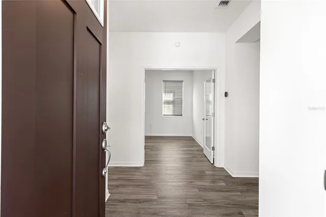 a view of a hallway with wooden floor