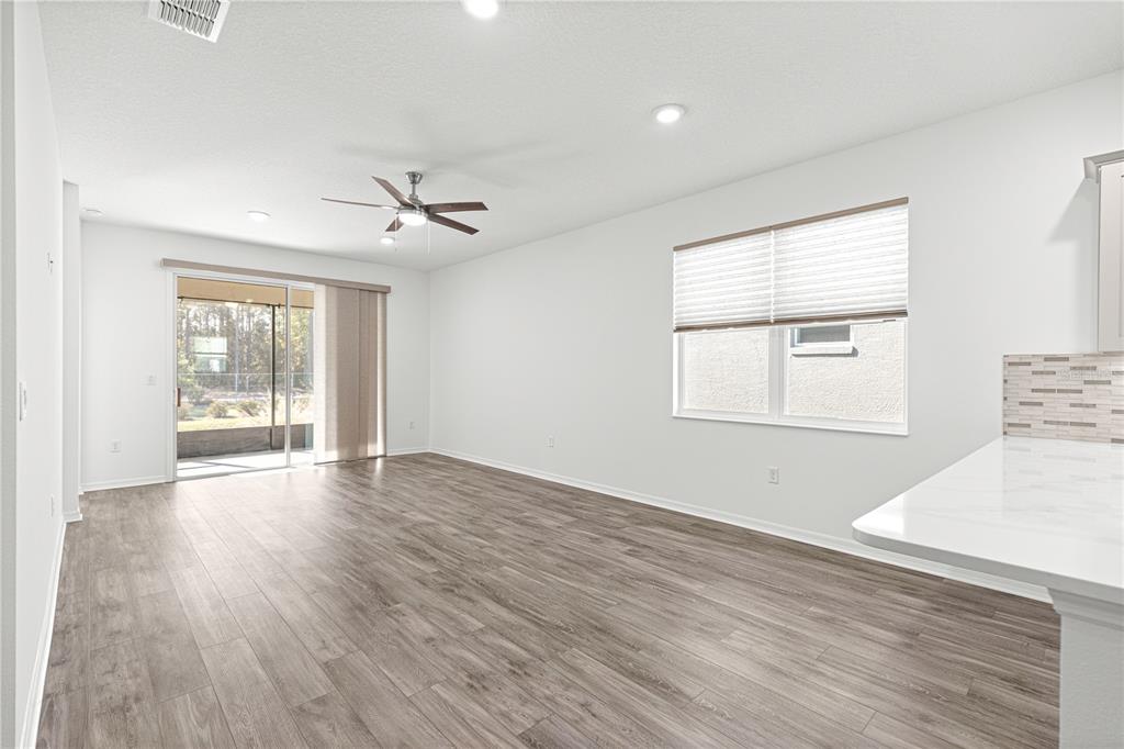 10242 Southwest 99th Lane Ocala, FL 34481 - Photo 14 of 51 an empty room with wooden floor and windows