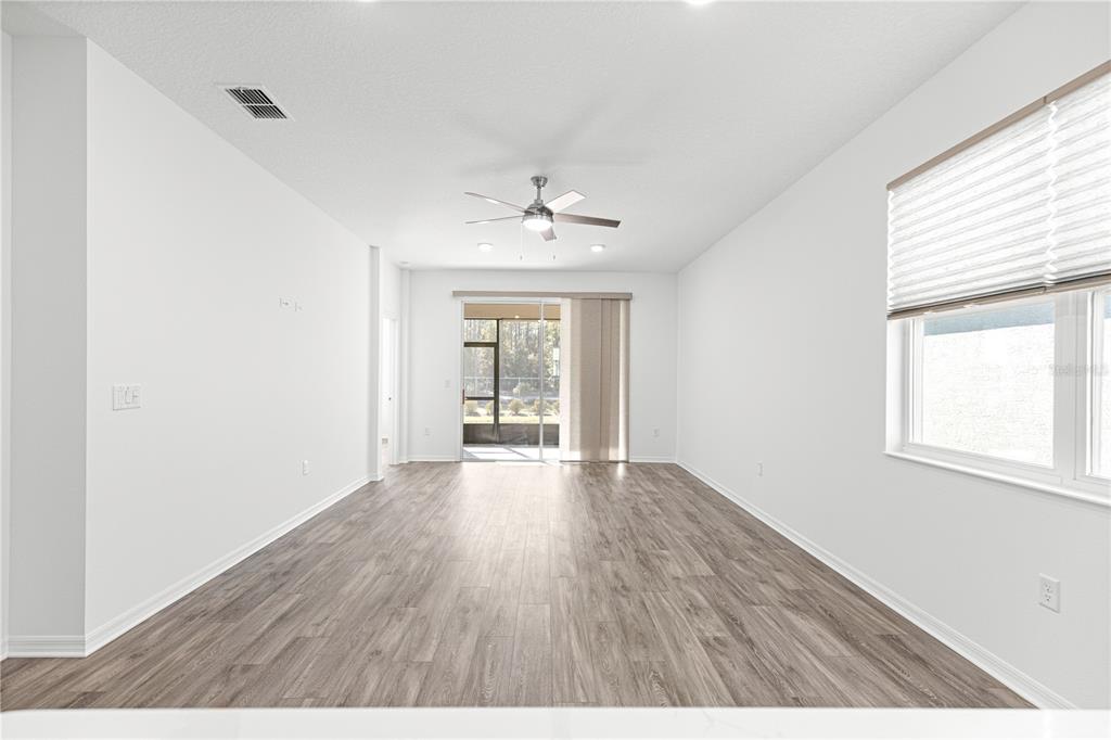 10242 Southwest 99th Lane Ocala, FL 34481 - Photo 15 of 51 an empty room with wooden floor and windows