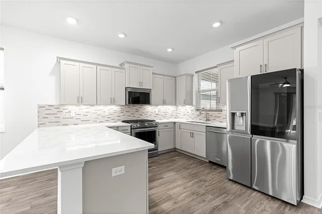 a kitchen with a refrigerator stove microwave and sink