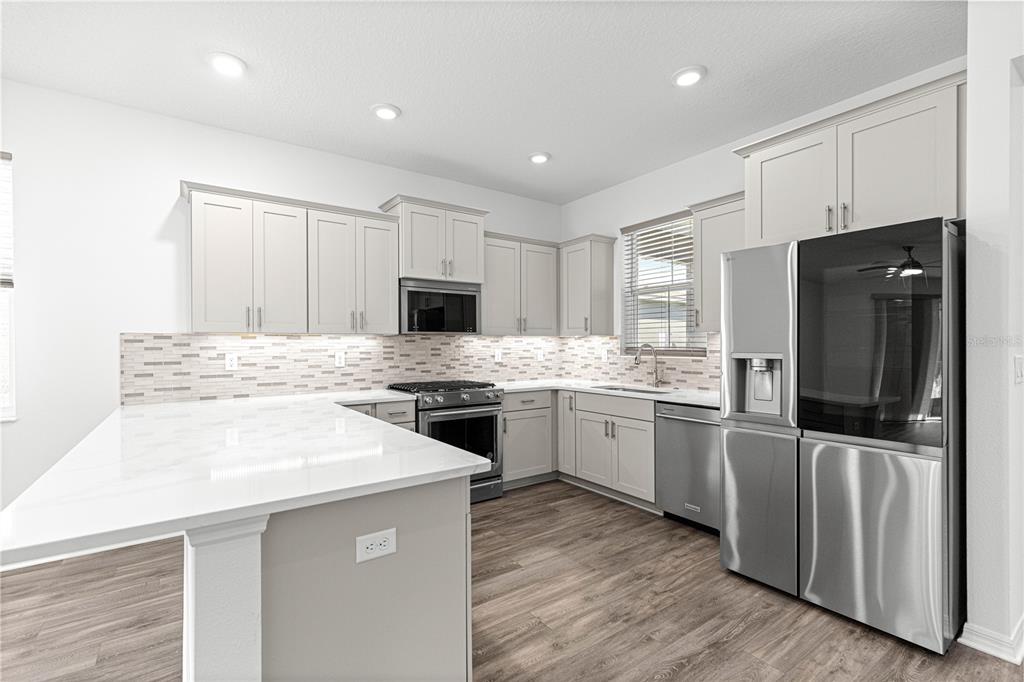 10242 Southwest 99th Lane Ocala, FL 34481 - Photo 17 of 51 a kitchen with a refrigerator stove microwave and sink