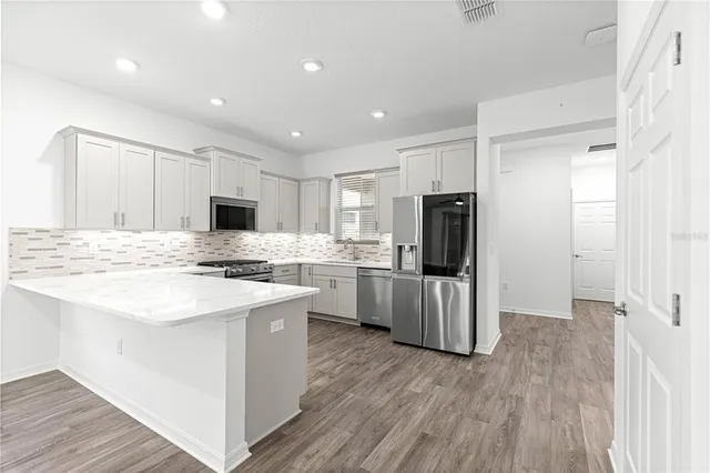 a kitchen with white cabinets and stainless steel appliances