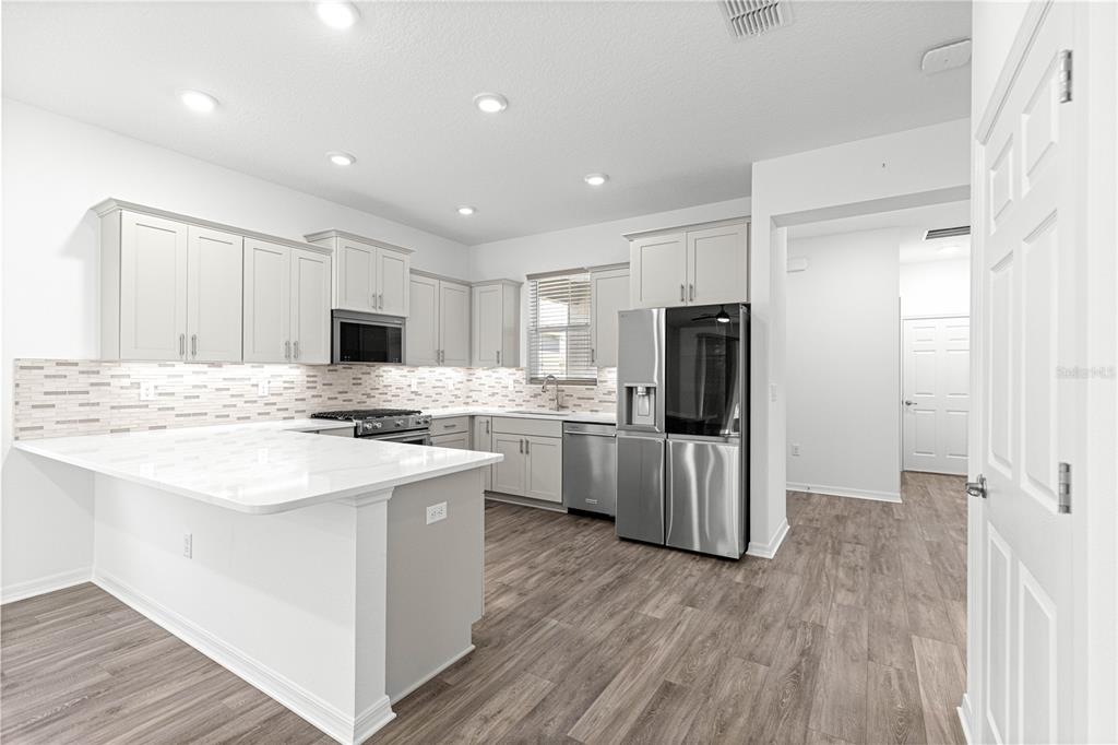 10242 Southwest 99th Lane Ocala, FL 34481 - Photo 18 of 51 a kitchen with white cabinets and stainless steel appliances