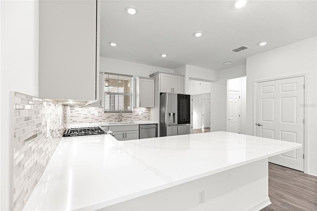 10242 Southwest 99th Lane Ocala, FL 34481 - Photo 21 of 51 a large white kitchen with kitchen island a sink stainless steel appliances and cabinets