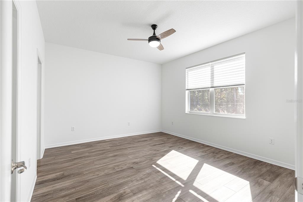 10242 Southwest 99th Lane Ocala, FL 34481 - Photo 24 of 51 an empty room with wooden floor and windows