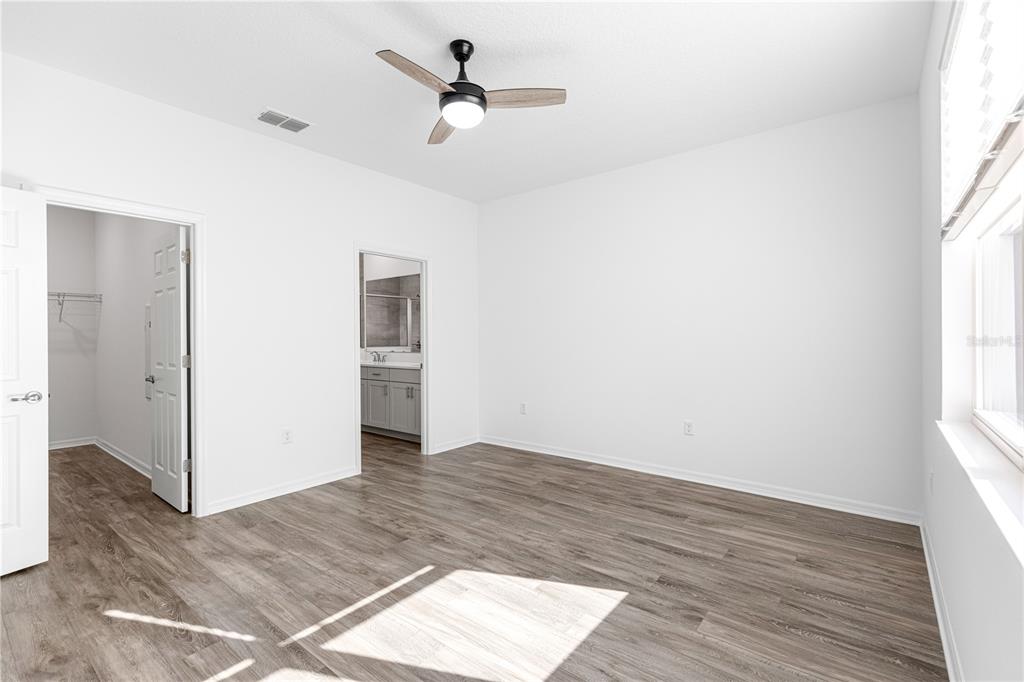 10242 Southwest 99th Lane Ocala, FL 34481 - Photo 26 of 51 an empty room with wooden floor chandelier and windows