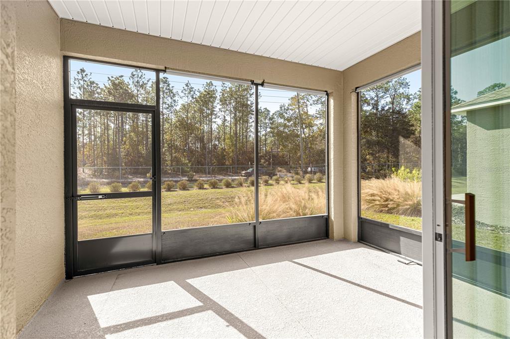 10242 Southwest 99th Lane Ocala, FL 34481 - Photo 44 of 51 a living room with a large window and a glass door