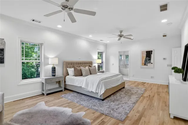 a spacious bedroom with a large bed chandelier and a window