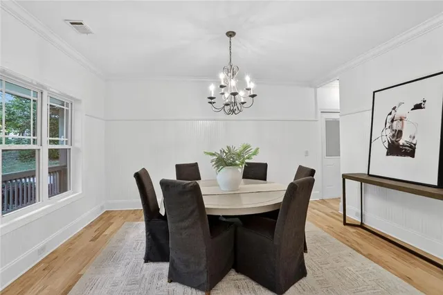 a view of a dining room with furniture a chandelier and wooden floor