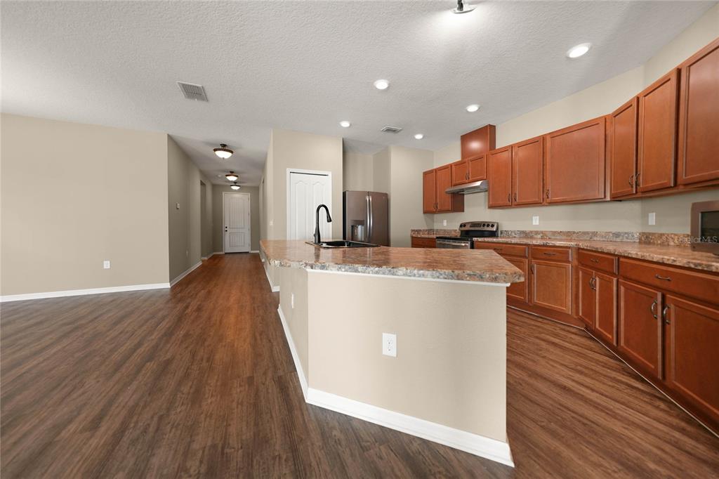 10147 Winding River Road Punta Gorda, FL 33950 - Photo 3 of 33 a kitchen with stainless steel appliances granite countertop a stove a sink dishwasher and a refrigerator with wooden floor