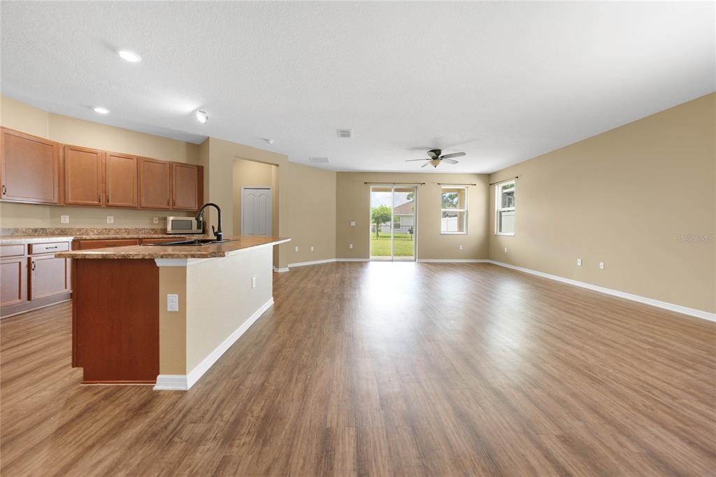 10147 Winding River Road Punta Gorda, FL 33950 - Photo 6 of 33 a large kitchen with stainless steel appliances granite countertop a large counter top a wooden floors and a view of living room