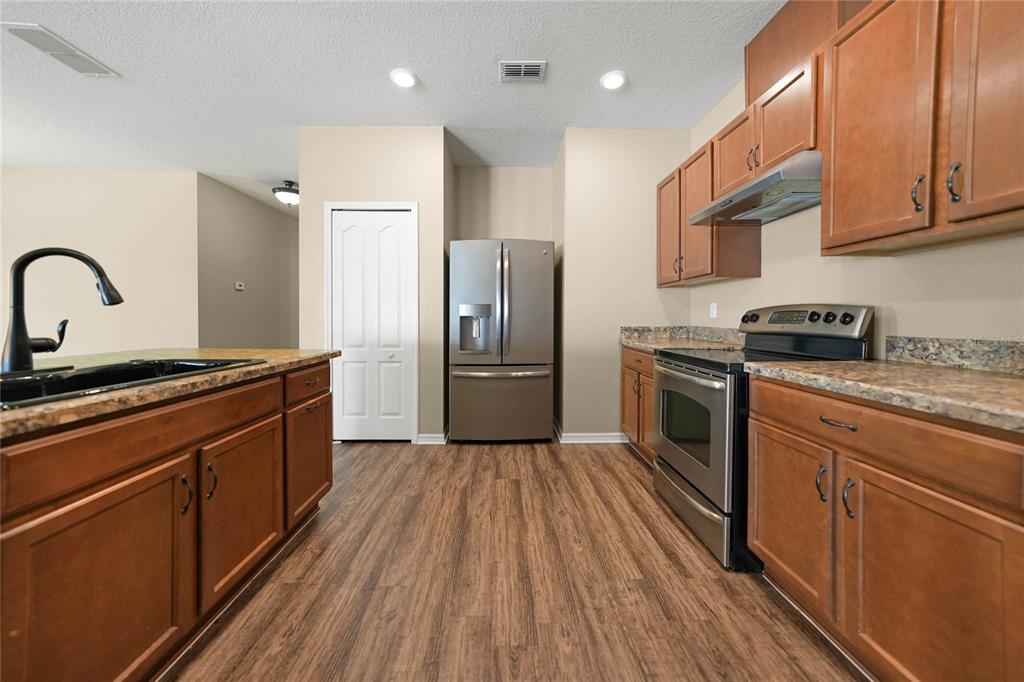 10147 Winding River Road Punta Gorda, FL 33950 - Photo 8 of 33 a kitchen with stainless steel appliances granite countertop a stove a sink and a refrigerator
