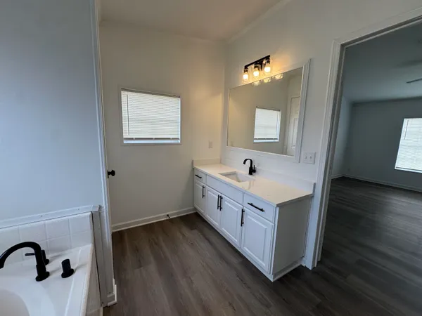 a kitchen with a sink cabinets and wooden floor