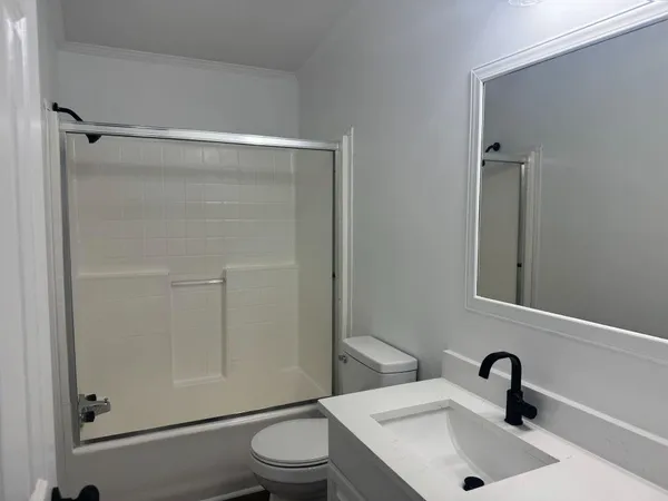 a bathroom with a sink toilet and shower