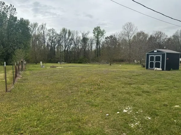 a yard with trees in the background
