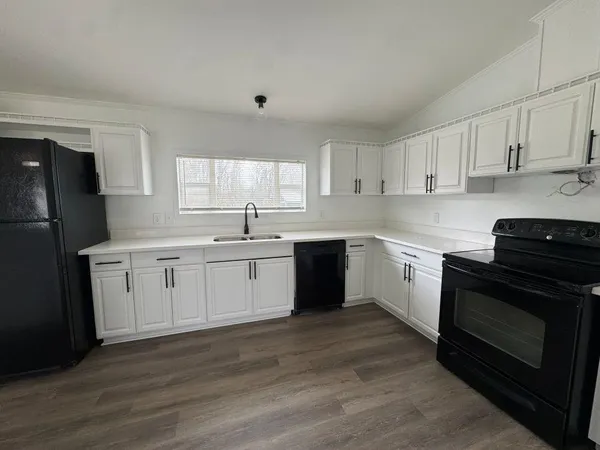 a kitchen with a white stove top oven and white cabinets