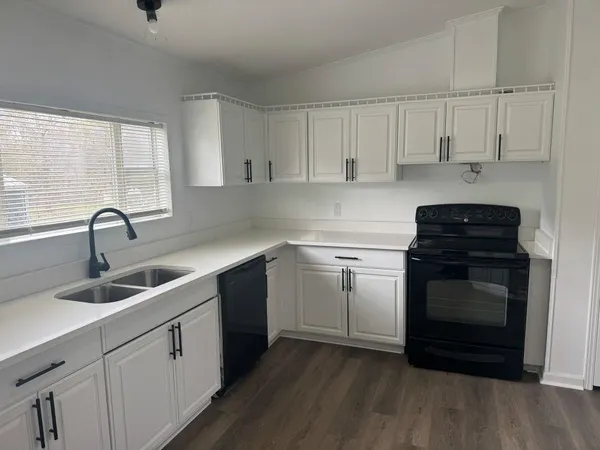 a kitchen with white cabinets appliances and sink