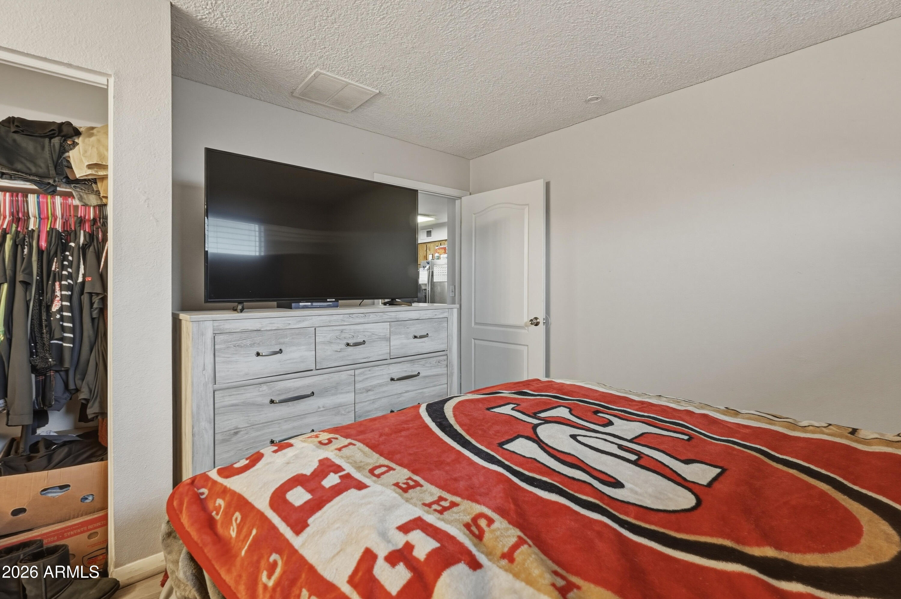 7233 West Hatcher Road Peoria, AZ 85345 - Photo 15 of 36 a bedroom with a bed and a flat screen tv