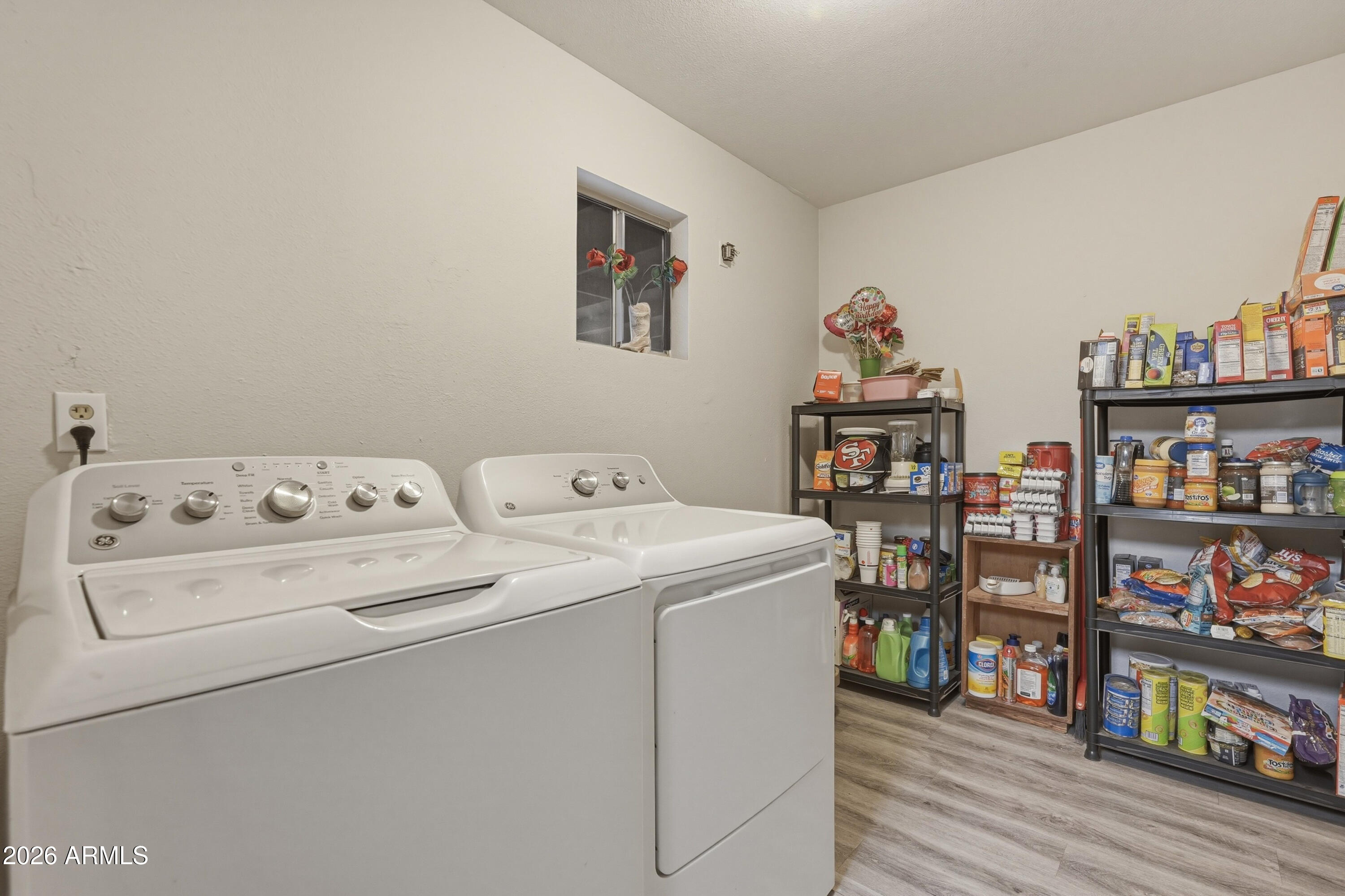 7233 West Hatcher Road Peoria, AZ 85345 - Photo 18 of 36 a utility room with dryer and book shelf