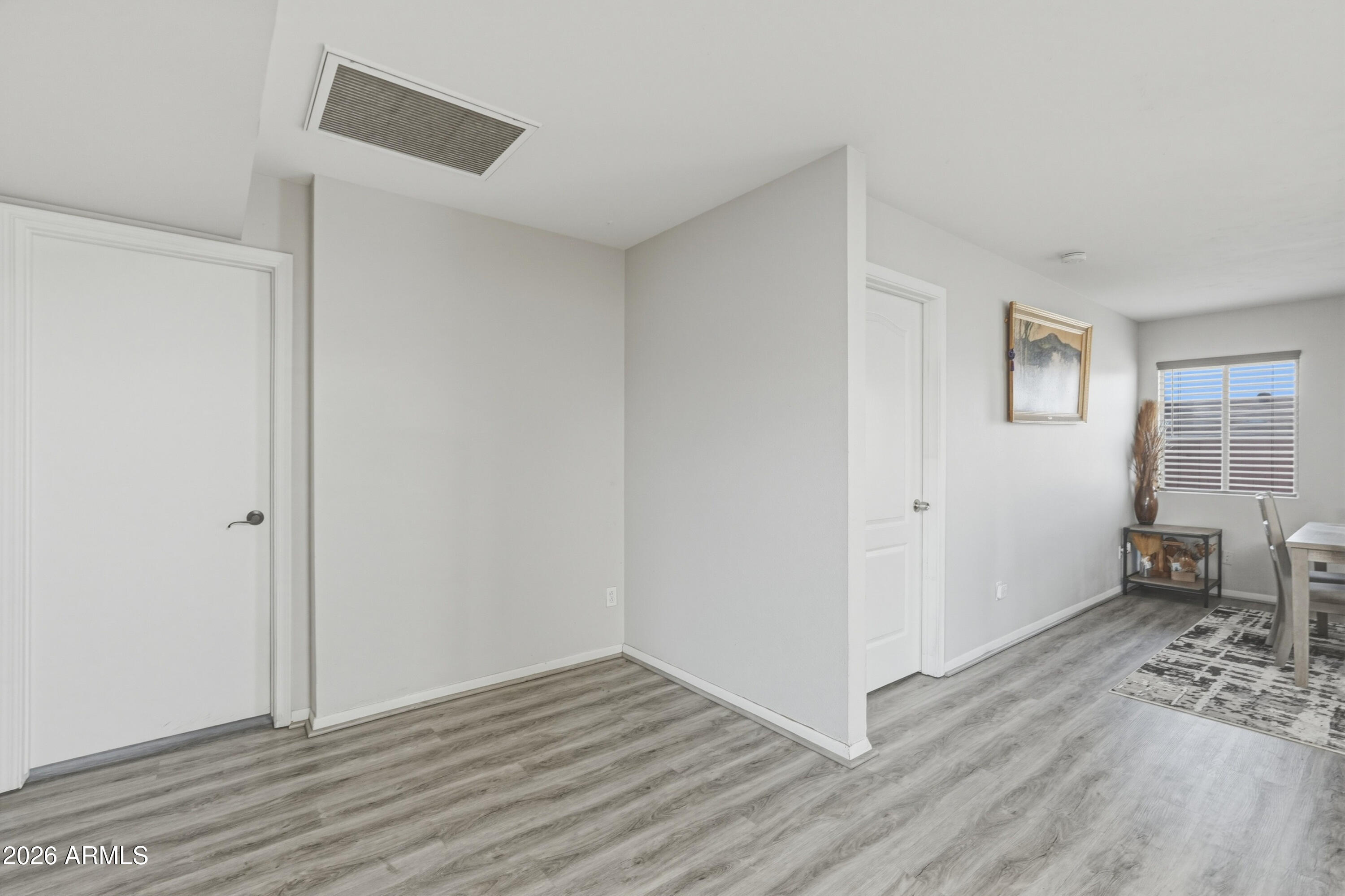7233 West Hatcher Road Peoria, AZ 85345 - Photo 24 of 36 a view of an empty room with wooden floor and a window