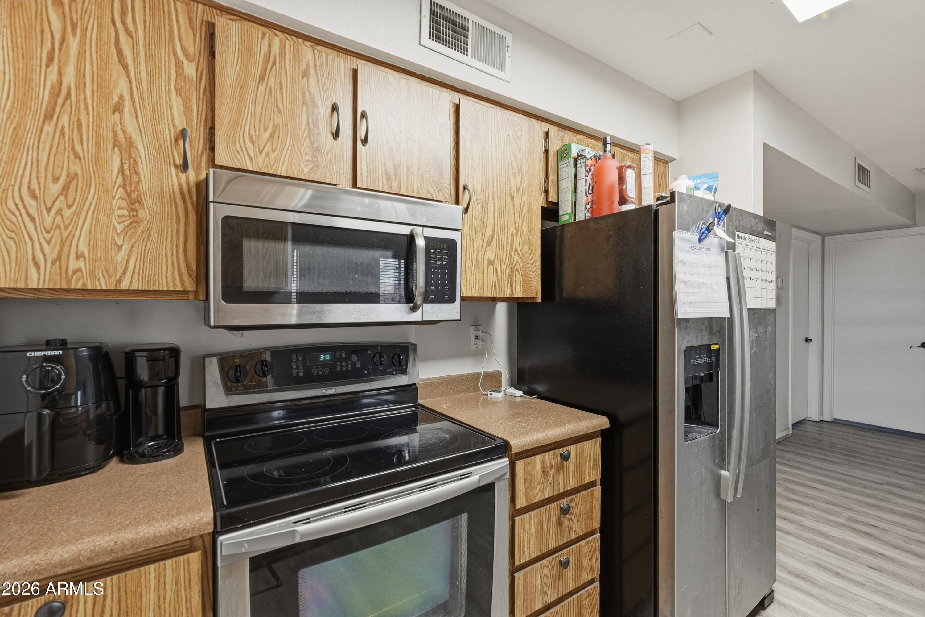 7233 West Hatcher Road Peoria, AZ 85345 - Photo 29 of 36 a kitchen with granite countertop cabinets and steel stainless steel appliances