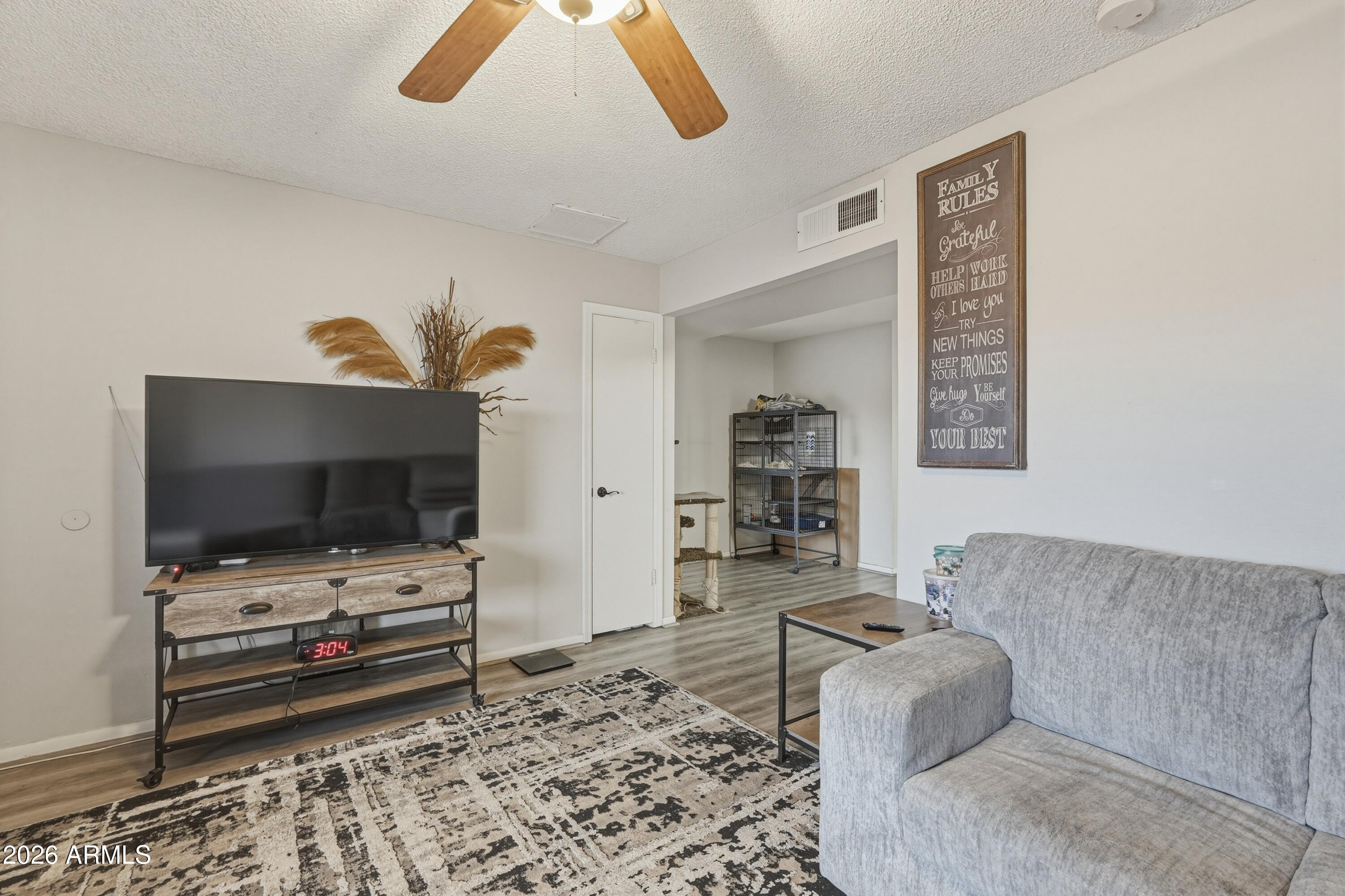 7233 West Hatcher Road Peoria, AZ 85345 - Photo 6 of 36 a living room with furniture and a flat screen tv