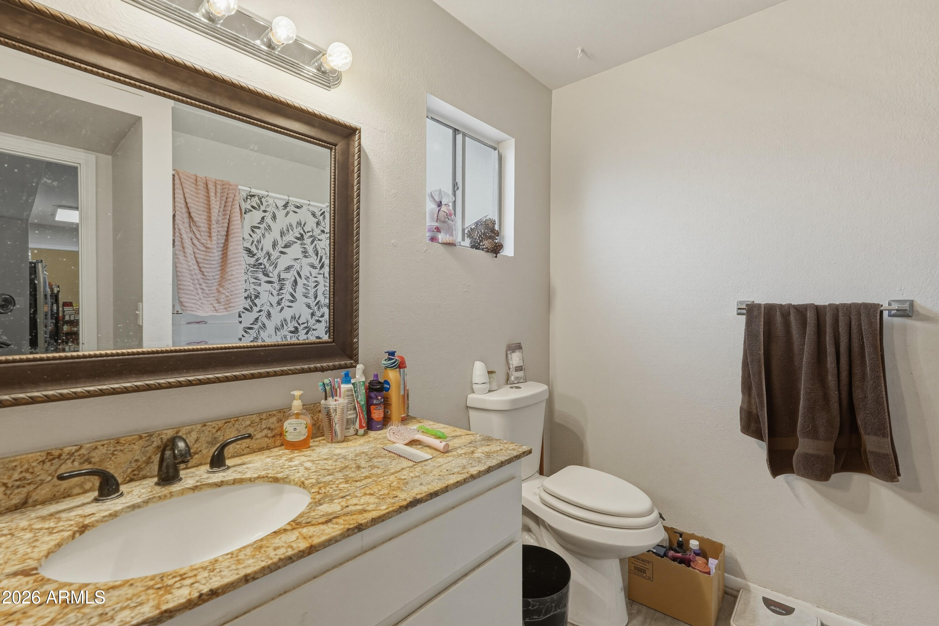 7233 West Hatcher Road Peoria, AZ 85345 - Photo 10 of 36 a bathroom with a granite countertop sink toilet and mirror