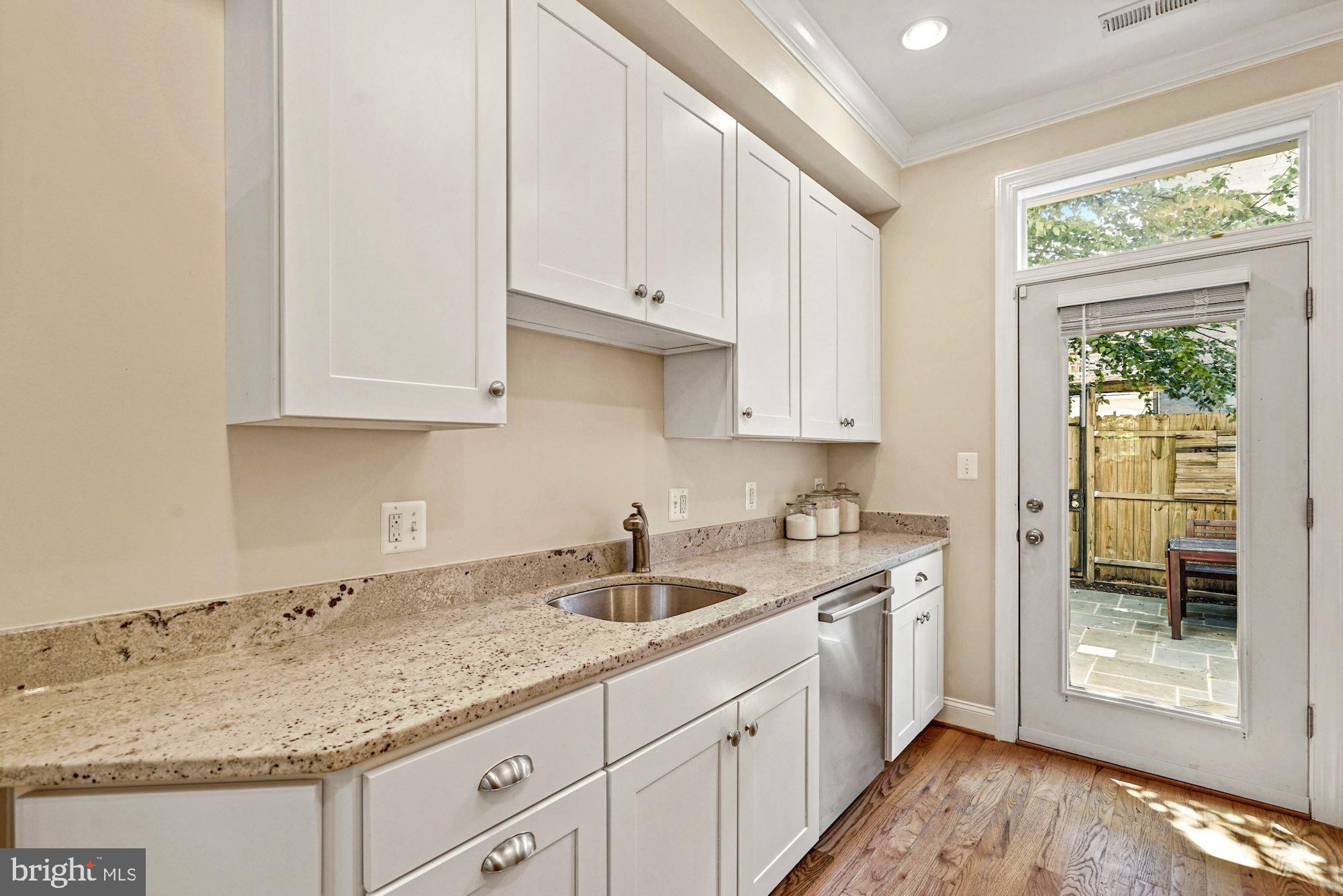 832 5th Street Northeast Washington, DC 20002 - Photo 10 of 35 a kitchen with granite countertop white cabinets and a sink