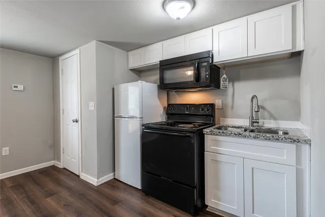 a kitchen with appliances a sink and cabinets