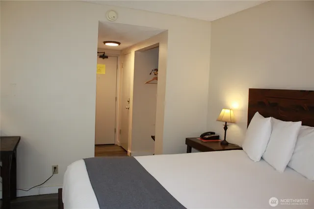 a bedroom with a bed and a lamp with wooden floor