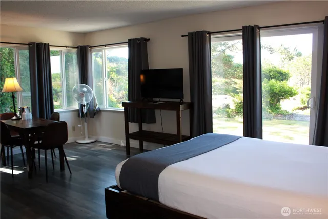 a bedroom with a bed and large windows