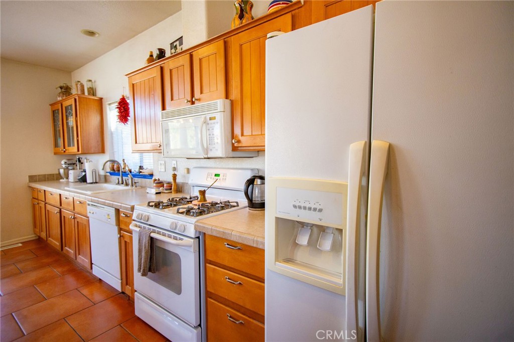 1106 Beach Drive Needles, CA 92363 - Photo 29 of 73 a kitchen with stainless steel appliances granite countertop a sink stove and refrigerator