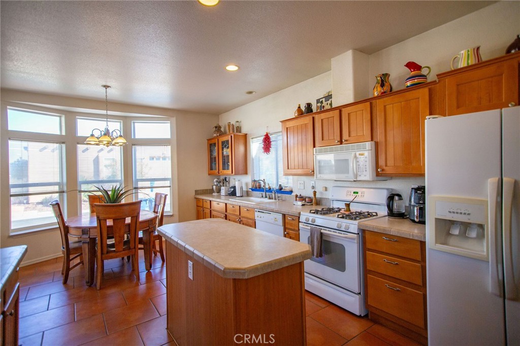 1106 Beach Drive Needles, CA 92363 - Photo 30 of 73 a kitchen with a table chairs stove and refrigerator