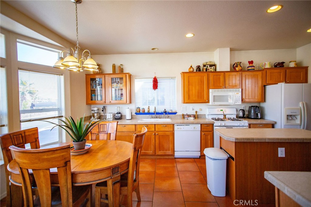 1106 Beach Drive Needles, CA 92363 - Photo 31 of 73 a kitchen with stainless steel appliances kitchen island granite countertop a table and chairs in it