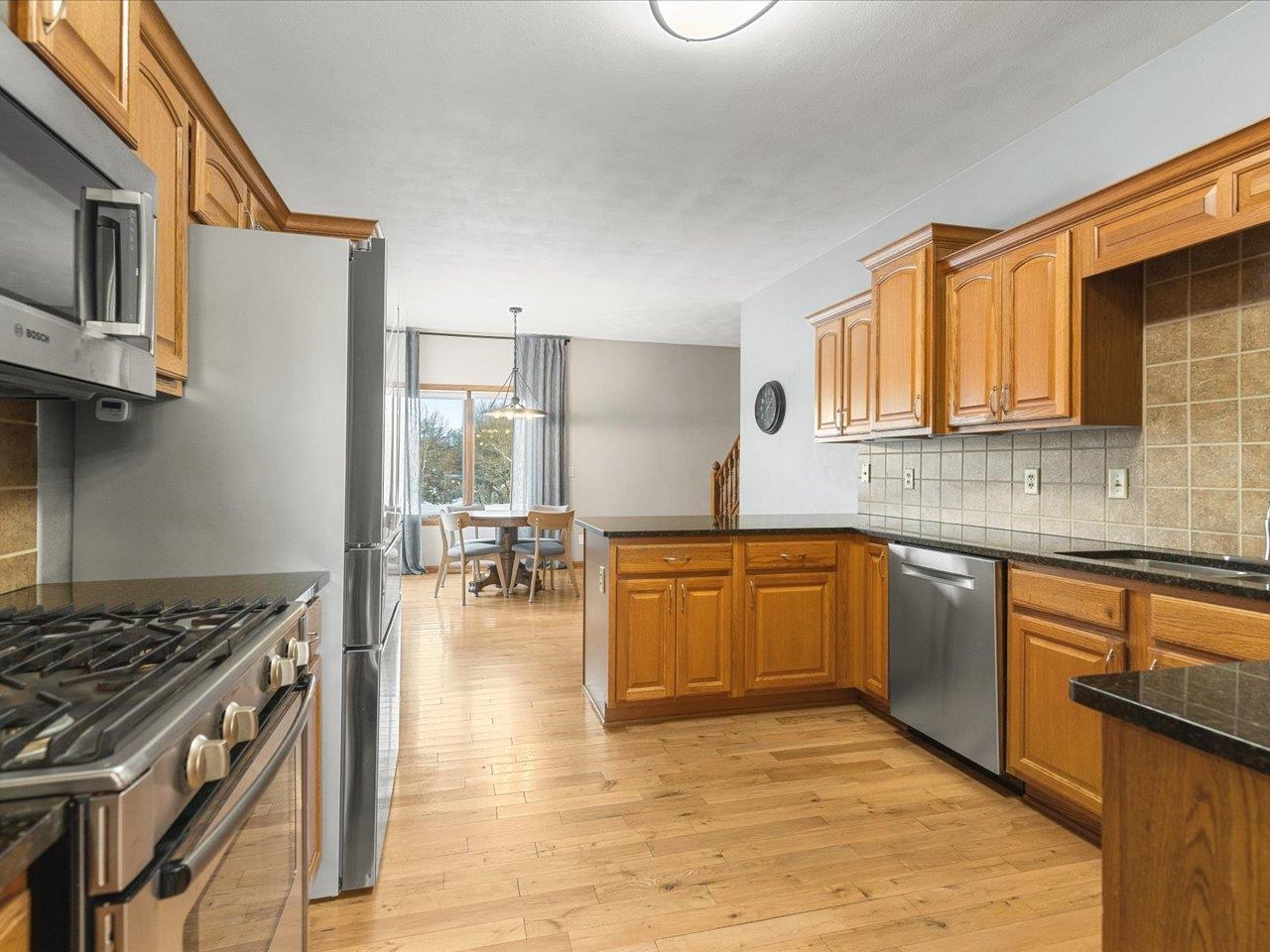 12375 Wildflower Lane Belvidere, IL 61008 - Photo 15 of 52 a kitchen with stainless steel appliances granite countertop a stove top oven a sink dishwasher and cabinets with wooden floor