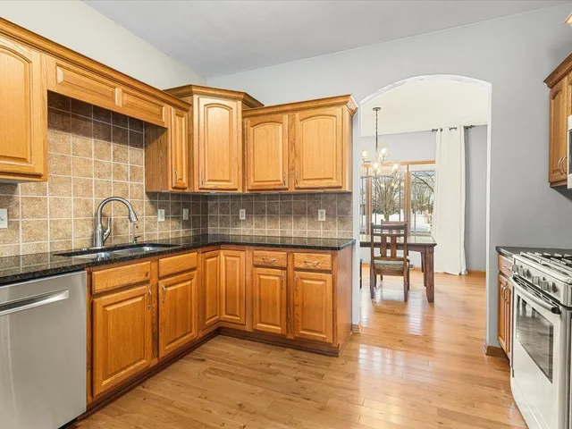a kitchen with stainless steel appliances granite countertop a stove a sink and a refrigerator