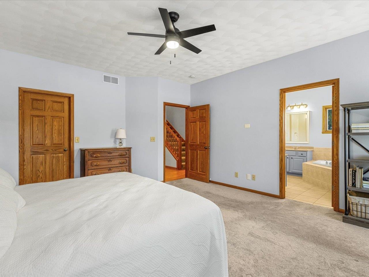 12375 Wildflower Lane Belvidere, IL 61008 - Photo 23 of 52 a bedroom with a large bed and a chandelier