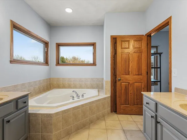 a bathroom with a tub sink and mirror