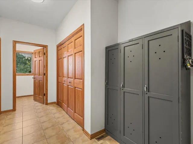 a view of a hallway with wooden floor and cabinet