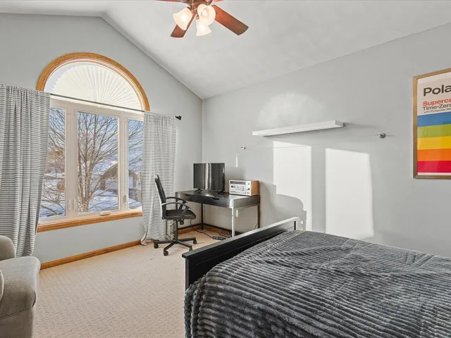 a bedroom with a bed and a large window