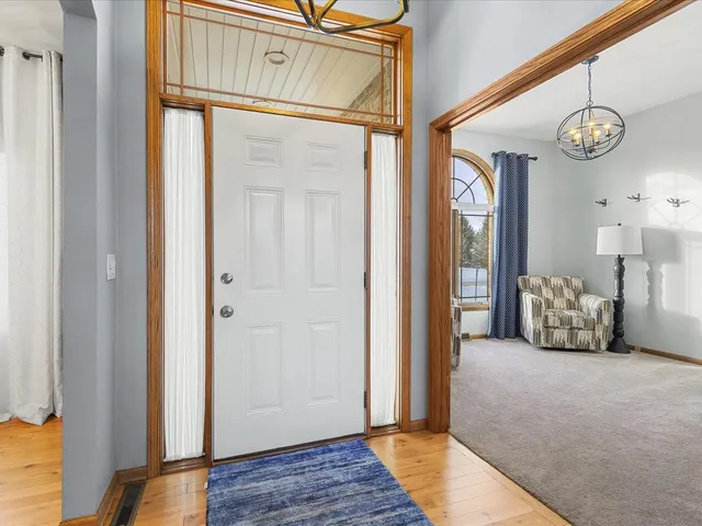 a view of a hallway with wooden floor and a door