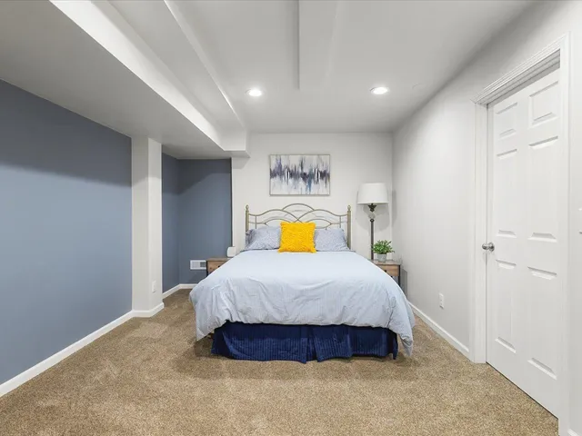 a bedroom with a bed and painting on the wall