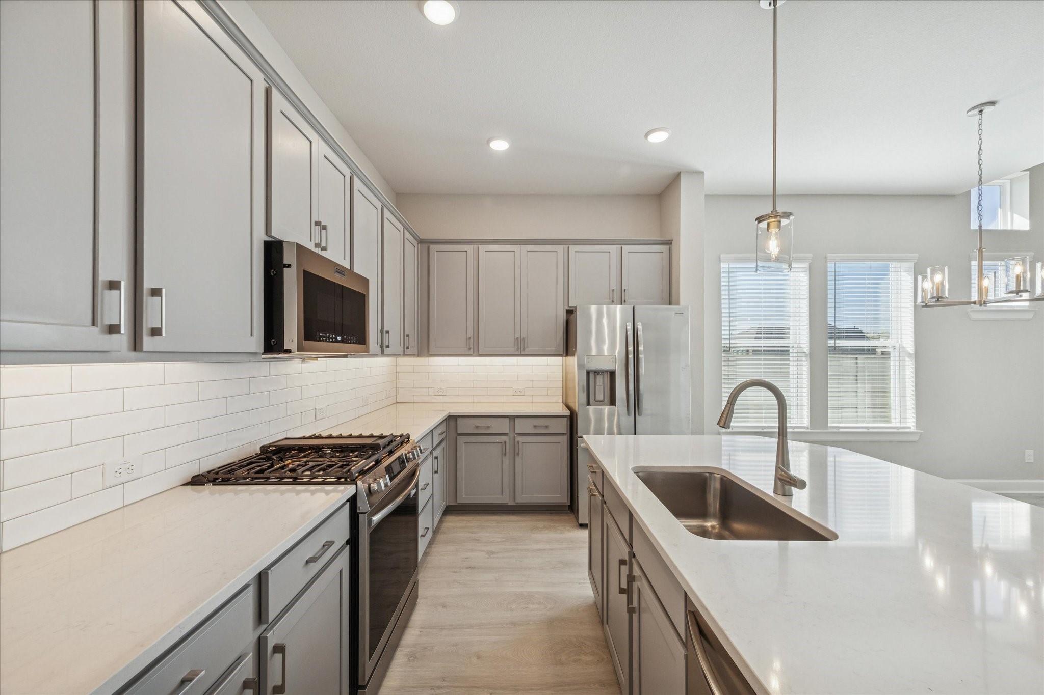 5518 Kindle Alley Manvel, TX 77578 - Photo 3 of 20 a kitchen with stainless steel appliances kitchen island a sink a stove and cabinets