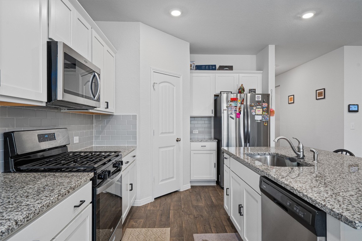 204 Connor Lane Georgetown, TX 78626 - Photo 11 of 31 a kitchen with stainless steel appliances granite countertop a sink stove and refrigerator