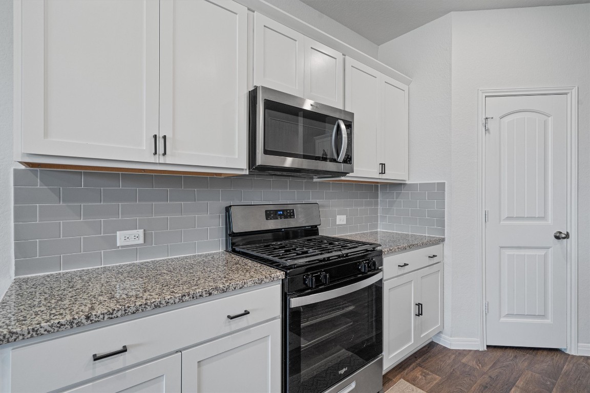 204 Connor Lane Georgetown, TX 78626 - Photo 12 of 31 a kitchen with granite countertop white cabinets and stainless steel appliances