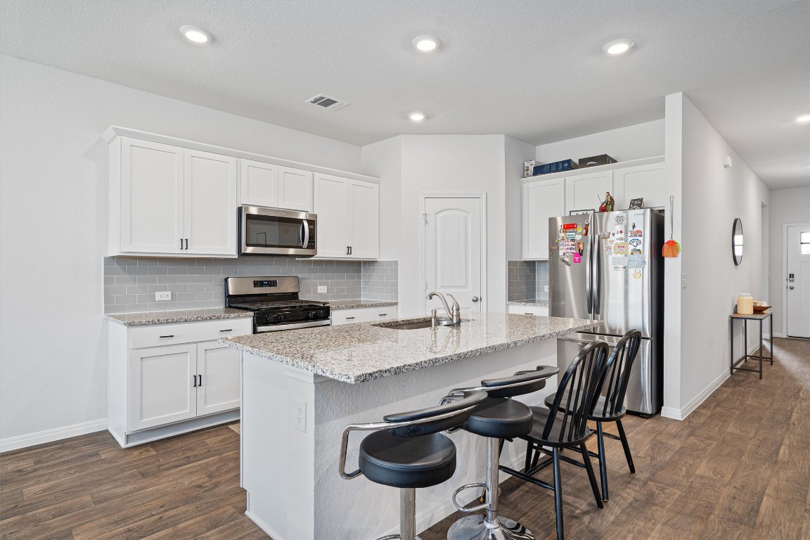 204 Connor Lane Georgetown, TX 78626 - Photo 10 of 31 a kitchen with stainless steel appliances granite countertop a table chairs microwave and sink