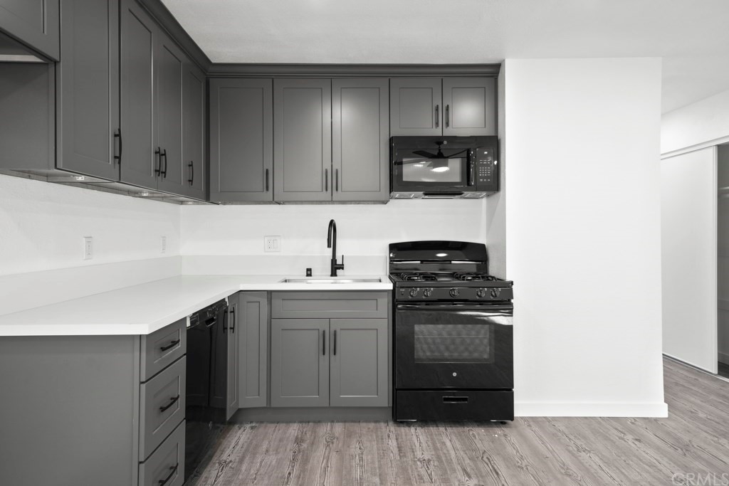1202 Mahanna Avenue Long Beach, CA 90813 - Photo 9 of 32 a kitchen with stainless steel appliances granite countertop a sink stove and microwave