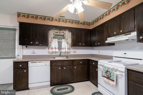 a kitchen with a sink dishwasher and a stove with wooden floor
